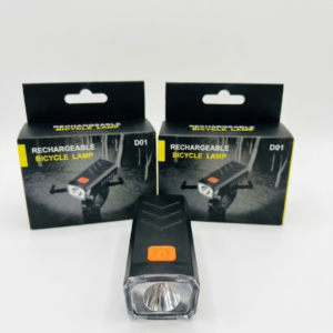 Linterna LED recargable para bicicleta modelo D01 situada frente a dos cajas de embalaje negras iguales.