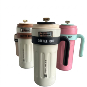 Tres vasos térmicos con asa y tapa, colores blanco, rosa y marrón, con logotipos de Stanley y marca Hengda.