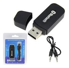 Receptor Bluetooth USB negro con su tapa, empaque original y cable auxiliar de 3.5mm sobre fondo blanco.