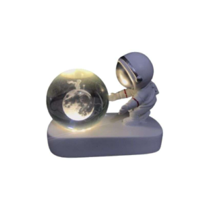 Lámpara LED con figura de astronauta sosteniendo una esfera de cristal que proyecta una luna iluminada.