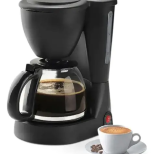 Cafetera eléctrica negra de filtro con jarra de vidrio llena de café, junto a una taza blanca con café y granos al lado.