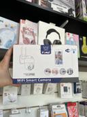 Mano sosteniendo la caja de una cámara de seguridad WiFi inteligente en una tienda de tecnología.